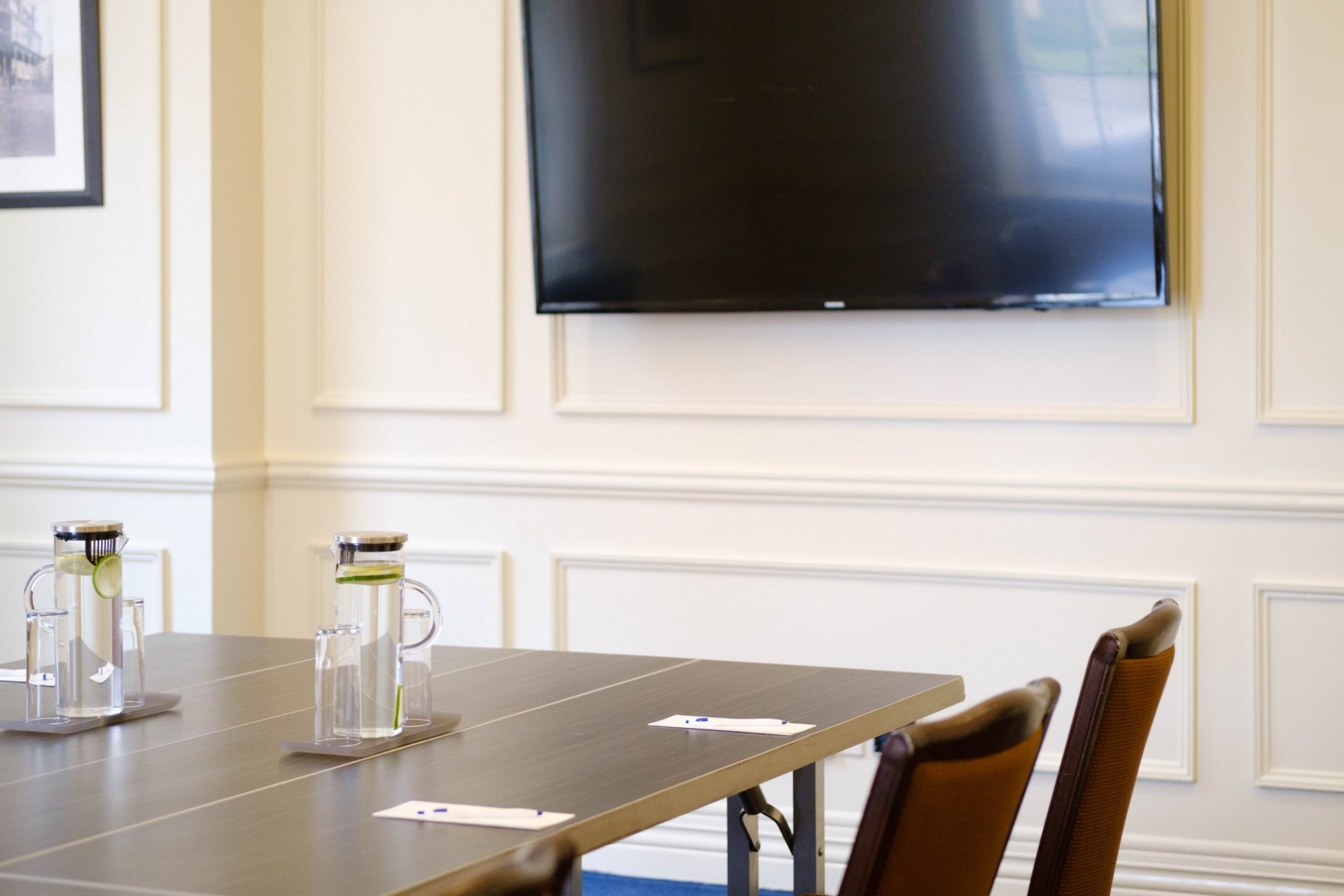 A flatscreen TV is mounted in the 1754 Boardroom