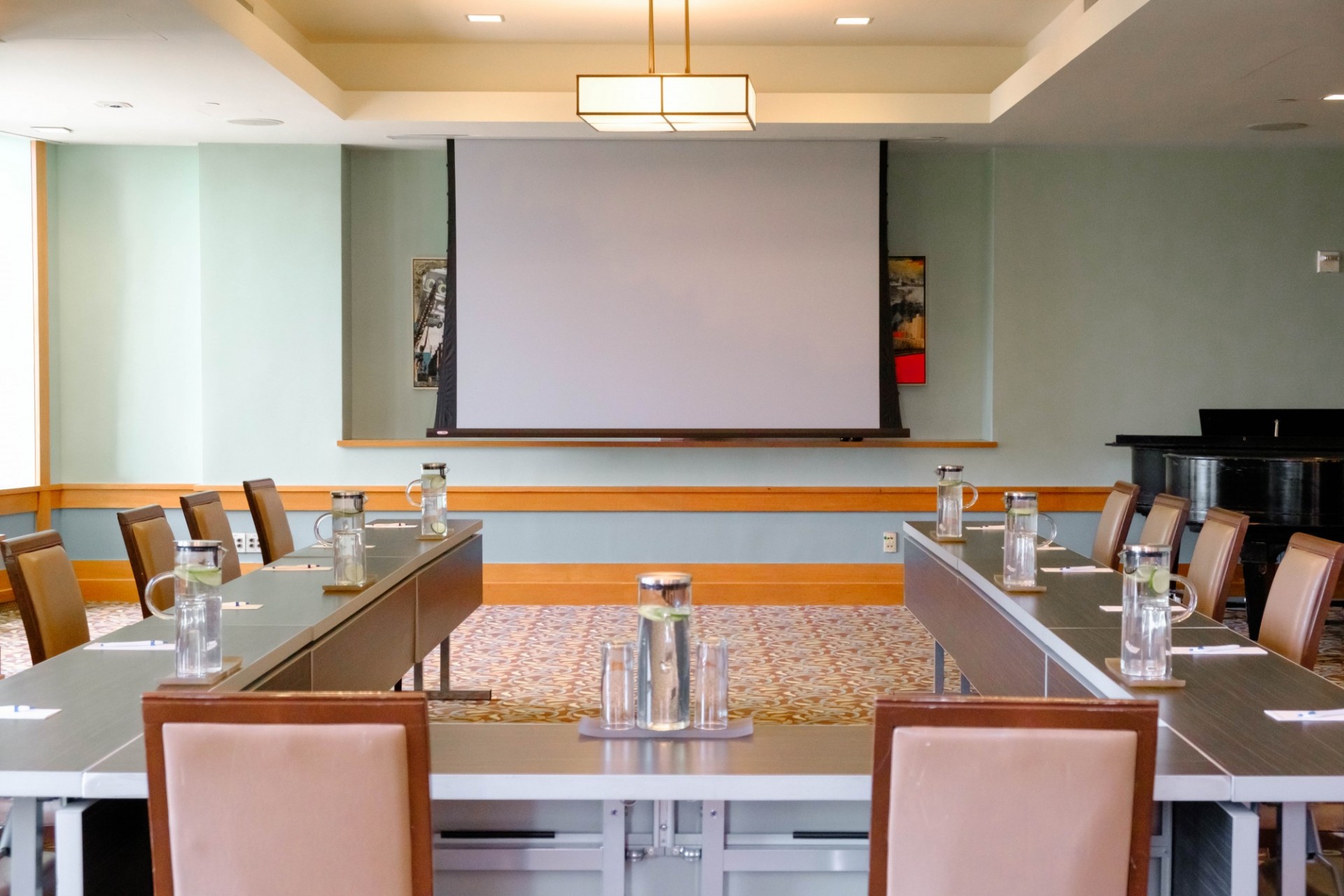 Tables in U formation face a projector screen in Garden Room 2