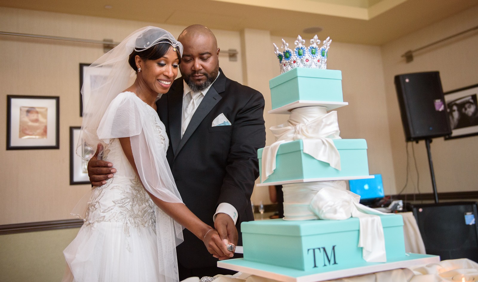 A couple cutting a slice of their custom wedding cake by Ron Ben-Israel. 