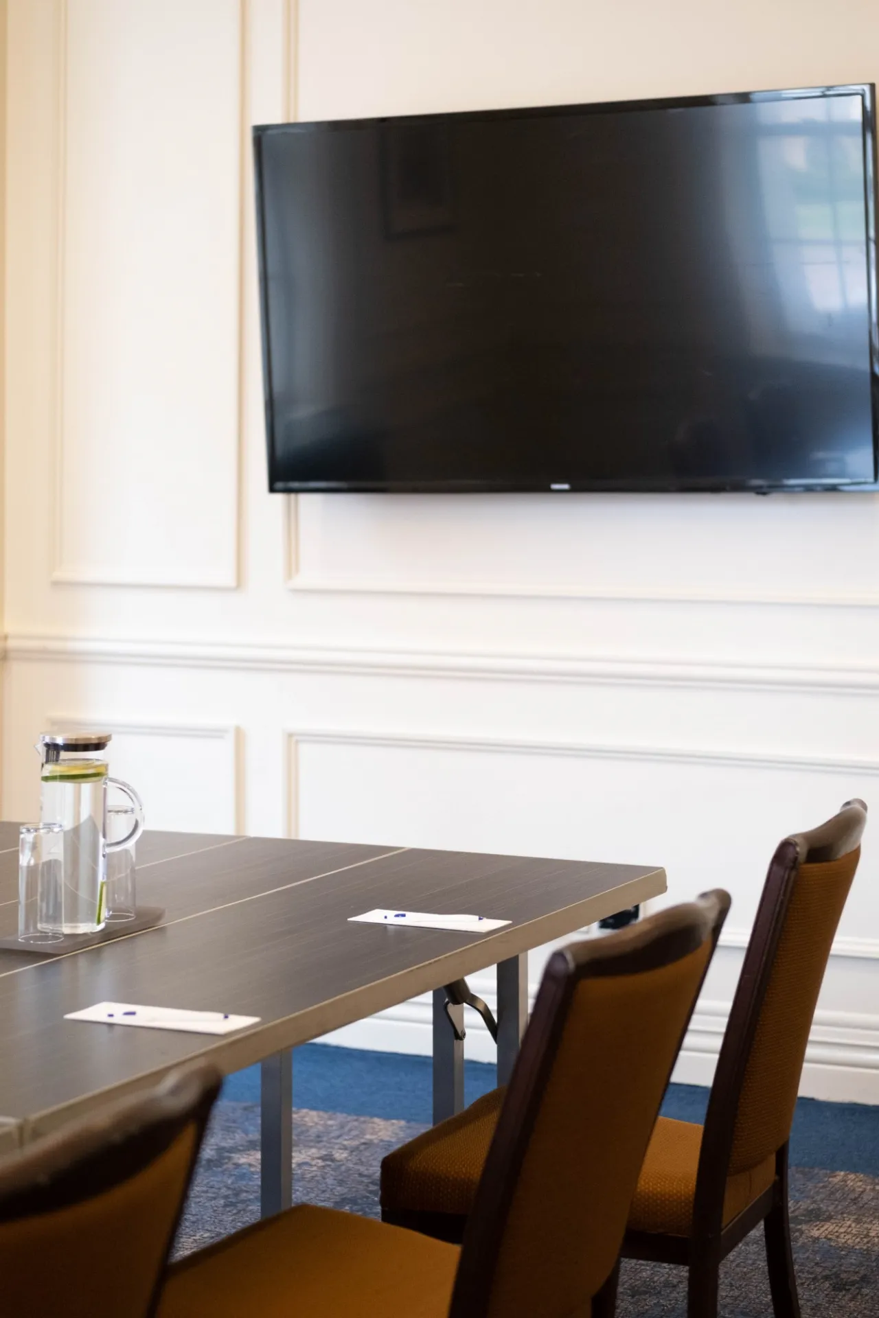 A flatscreen TV is mounted in the 1754 Boardroom
