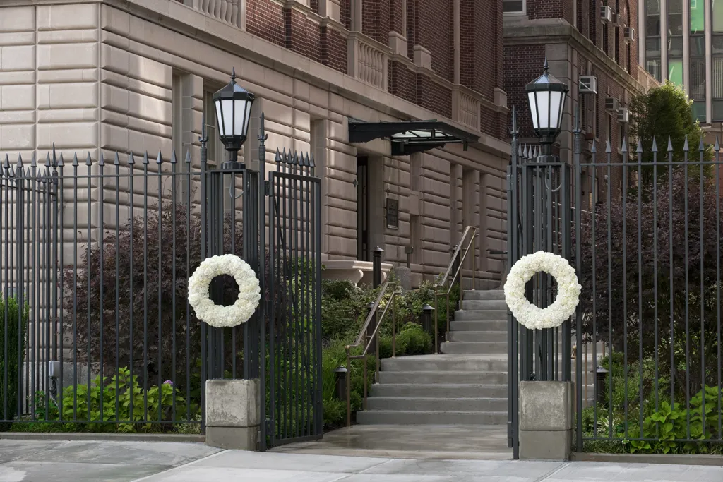 Wreaths made of white roses hang on either side of the open gate that leads to Faculty House.
