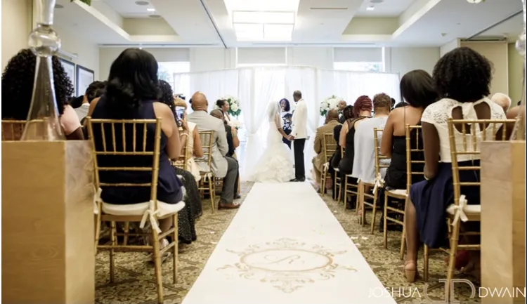 A couple hold hands while being married at Faculty House.
